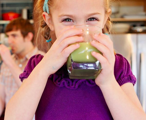 Smiling girl drinking smoothie